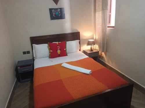 Residence perle de l'ocean في ميرلفت: غرفة نوم مع سرير مع بطانية ومخدات ملونة