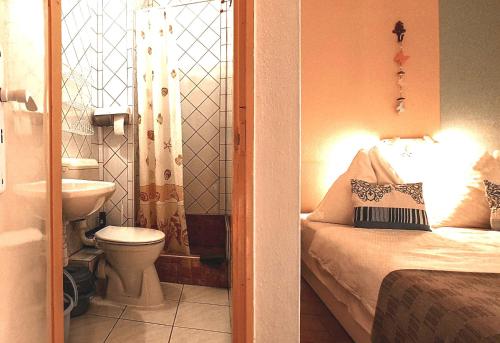 a bathroom with a bed and a toilet and a sink at Aqua Ház Panzió 2 in Balatonfüred