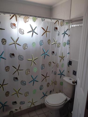 baño con cortina de ducha con estrella de mar en Cabañas Guayacanes, en Coquimbo