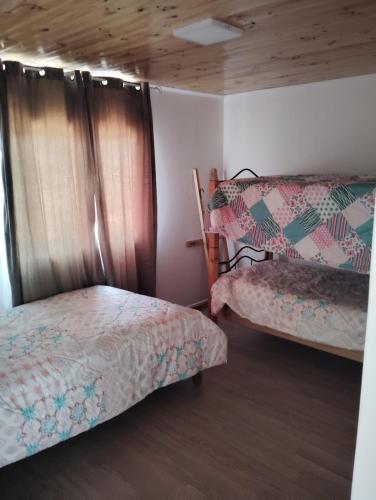 a room with two twin beds and a window at Cabañas Guayacanes in Coquimbo