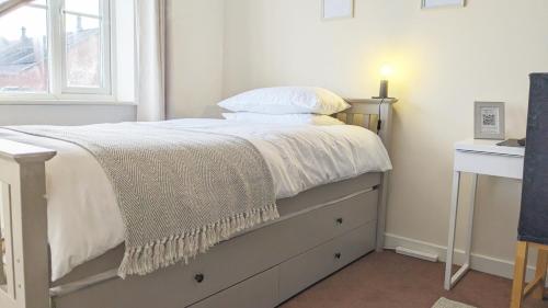 sypialnia z łóżkiem z białą pościelą i oknem w obiekcie Spacious Room with Parking TV Wi-Fi Desk Kettle w mieście Long Eaton