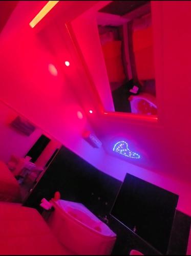 a room with red lights and a bed with a monitor at B&B GRECALE Suite & Spa in Rende