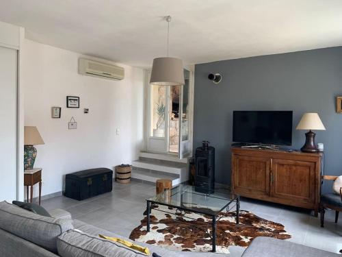 sala de estar con sofá y TV en Jolie maison individuelle dans l’extrême sud, en Monacia-d'Aullène