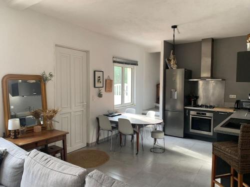 sala de estar con mesa y cocina en Jolie maison individuelle dans l’extrême sud, en Monacia-d'Aullène