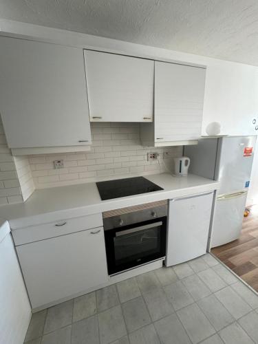 una cucina bianca con armadi bianchi e piano cottura di Perfect in the centre with view a Londra