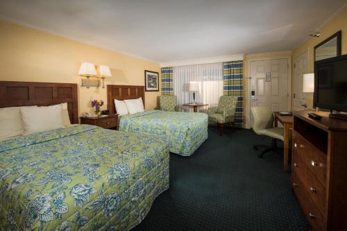 a hotel room with two beds and a flat screen tv at Juniper Hill Inn in Ogunquit