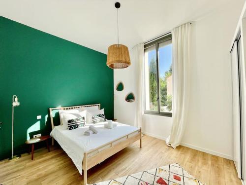 - une chambre verte et blanche avec un lit et une fenêtre dans l'établissement Incroyable Villa Jardin Piscine - Coeur de Ville -, à Montpellier