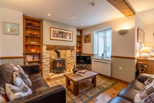 a living room with a couch and a fireplace at Moorhens in Somerford Keynes