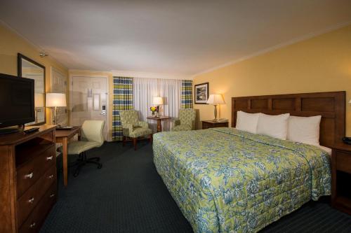 a hotel room with a bed and a flat screen tv at Juniper Hill Inn in Ogunquit