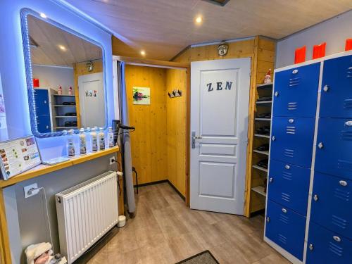- un casier avec des casiers bleus et une porte dans l'établissement Roulotte cosy avec kitchenette, ruisseau apaisant et espace bien-être, nuit insolite à Ferdrupt - FR-1-589-444, à Ferdrupt