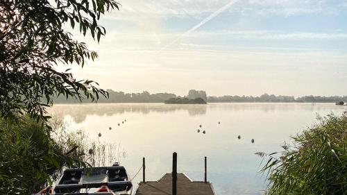 a boat on a lake with birds in the water at Moorhens in Somerford Keynes
