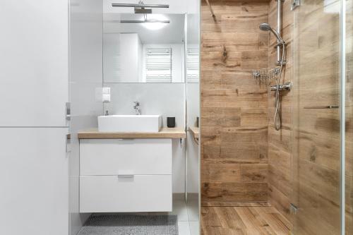 bagno con lavandino bianco e doccia di Apartament Chopina - Unique Apartments a Stettino