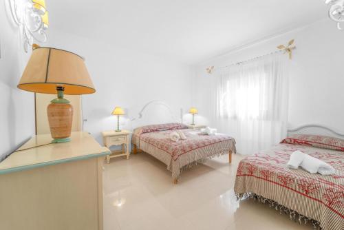 1 dormitorio con 2 camas y una lámpara en una mesa en Lussuosa Dimora Vista Mare con Piscina e Spiaggia a 300 MT, en Liscia di Vacca