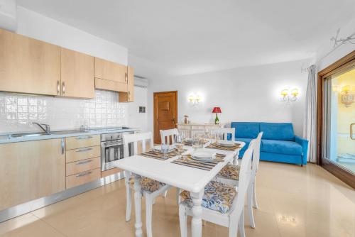 a kitchen and dining room with a white table and chairs at Lussuosa Dimora Vista Mare con Piscina e Spiaggia a 300 MT in Liscia di Vacca