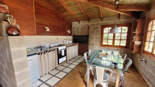 a kitchen with a glass table and white appliances at Casa en condominio in El Calafate