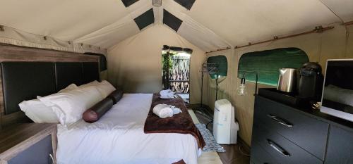 a bedroom with a large bed in a tent at Tot Hier Toe in Phalaborwa