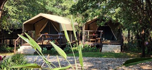 a tent in the middle of a yard with trees at Tot Hier Toe in Phalaborwa