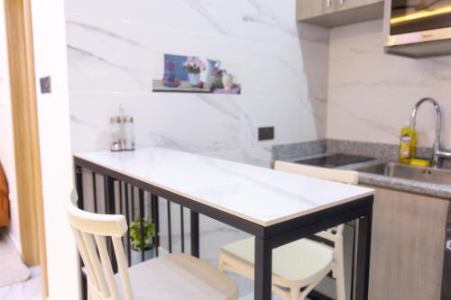una cocina con encimera en blanco y negro y fregadero en Cozy Studio Apartment, East Airport, en Accra