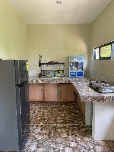 a kitchen with granite counter tops and a refrigerator at Buhay Probinsya - Bubolongan in El Nido