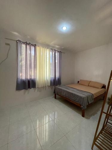 a bedroom with a bed and a window at Buhay Probinsya - Bubolongan in El Nido