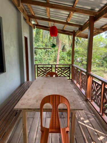 a wooden table and chairs on a wooden deck at Buhay Probinsya - Bubolongan in El Nido