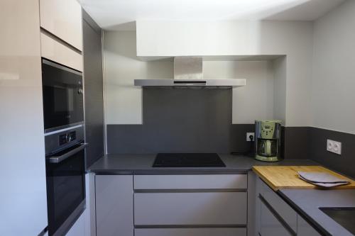 a small kitchen with a stove and a microwave at Hôtel Triton in Collioure