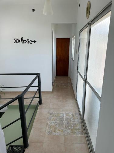 a hallway with a glass door and a floor at Departamentos Crisol in San Fernando del Valle de Catamarca