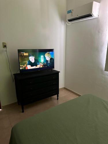a bedroom with a flat screen tv on a dresser at Departamentos Crisol in San Fernando del Valle de Catamarca