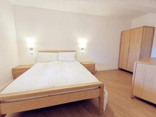 1 dormitorio con 1 cama grande y armario de madera en 24 CLIFF APARTMENT-3 BED-GROUND FLOOR-SEA VIEWS, en Trearddur