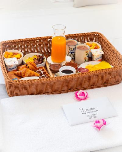 a basket filled with food and a glass of orange juice at Evasion en plein cœur de la ville T3 Jacuzzis Sauna et piscine au centre de Port-Louis in Port-Louis