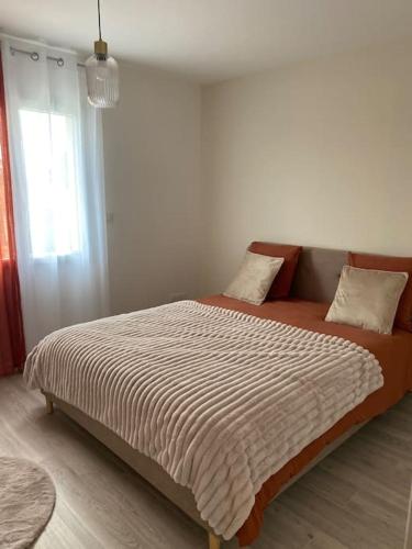 a bed sitting in a room with a window at Villa by Nesma in Châtellerault