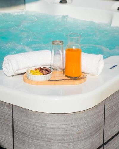 a tray of food and a glass of orange juice next to a swimming pool at Evasion en plein cœur de la ville T3 Jacuzzis Sauna et piscine au centre de Port-Louis in Port-Louis
