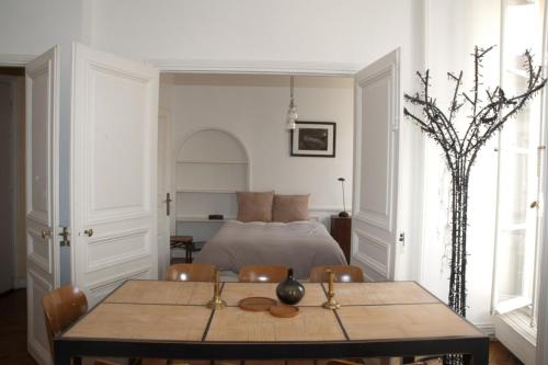 パリにあるDream Catcher 3Bdr Paris apartmentのベッドルーム1室(ベッド1台、テーブル、椅子付)
