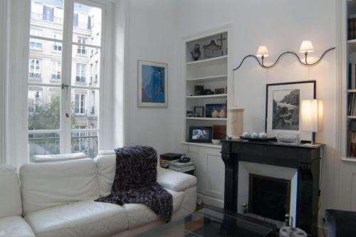 un salon avec un canapé blanc et une cheminée dans l'établissement Dream Catcher 3Bdr Paris apartment, à Paris
