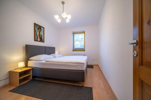 Schlafzimmer mit einem Bett, einem Fenster und einer Tür in der Unterkunft Apartment Riviera 500-15 Lipno Home in Lipno nad Vltavou