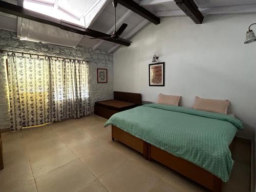 um quarto com uma cama com um edredão verde em EMERALD TRAIL BHIMTAL em Bhimtal