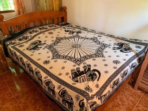ein Bett mit einer Decke darüber in der Unterkunft Shadow lake villa in Habaraduwa Central