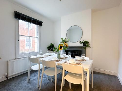 a dining room with a table with chairs and a mirror at Stylish & Spacious City Centre 3-Bedroom Townhouse - Sleeps 6 in Canterbury