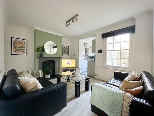 a living room with two couches and a fireplace at Stylish & Spacious City Centre 3-Bedroom Townhouse - Sleeps 6 in Canterbury