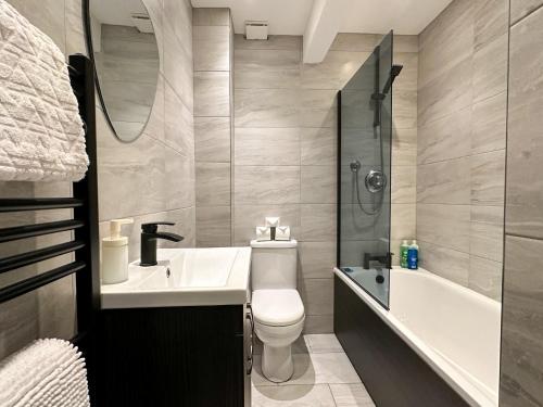 a bathroom with a toilet and a sink and a tub at Stylish & Spacious City Centre 3-Bed Townhouse with Private Walled Courtyard in Canterbury