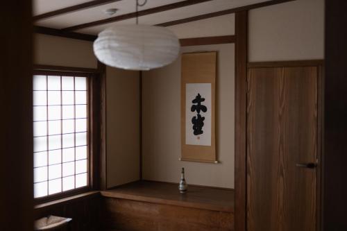 a room with a hallway with a chandelier and a door at 杜人舎 in Nanto