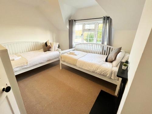two white beds in a room with a window at Oxford - Private House with Garden & Parking 16 in Oxford