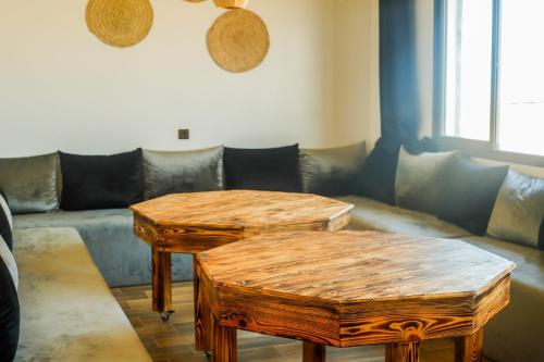 a living room with two tables and a couch at Dar Iziki in Sidi Kaouki