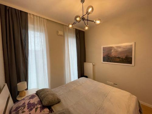 a bedroom with a bed and a large window at Essence Lux Apartment, free parking, self check-in 24h in Poznań