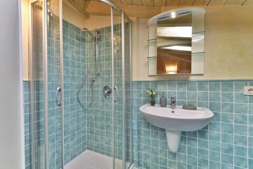 uma casa de banho com um lavatório e um chuveiro em Appartamento Al Porto Vecchio - Rebomaholidays em Gargnano