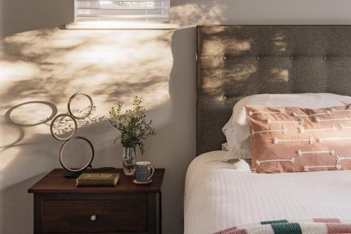 a bedroom with a bed and a nightstand with a mirror at Yewbeck: brand new, garden views in Windermere