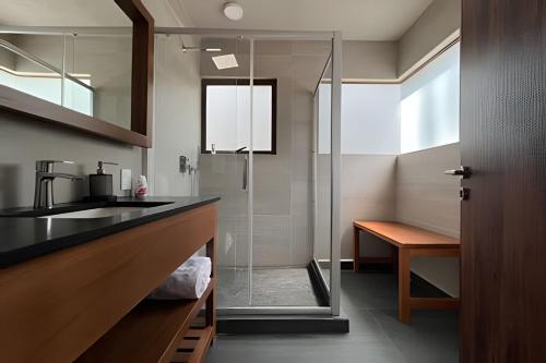 a bathroom with a glass shower and a sink at Casa con alberca y jacuzzi in Avándaro