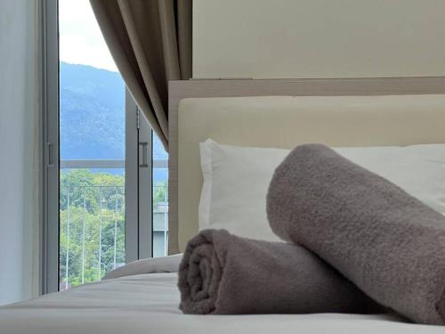 a bedroom with a white bed with a large window at Comfy 2 Bedder Retreat Homestay near Taiping Lake Garden with Netflix in Taiping