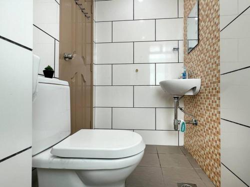 ein weißes Bad mit einem WC und einem Waschbecken in der Unterkunft Comfy 2 Bedder Retreat Homestay near Taiping Lake Garden with Netflix in Taiping