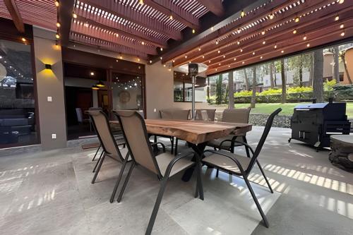 a dining room with a wooden table and chairs at Casa con alberca y jacuzzi in Avándaro